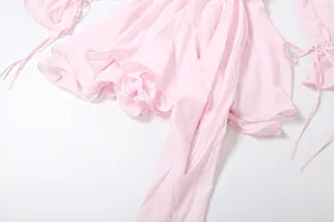 Dettaglio di un abito rosa con maniche a campana svasate e nastri delicati da annodare