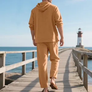 Hombre caminando por un muelle de madera con un conjunto informal de lino naranja