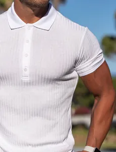 Close-up of white ribbed polo shirt showing muscular fit and soft fabric texture.
