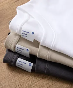 Detailed view of the crew neck collar and labels of folded high-quality cotton t-shirts