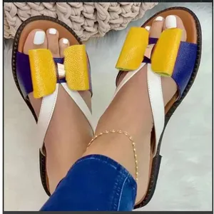 Women's flat sandals featuring a large yellow bow and color-blocked blue and white design