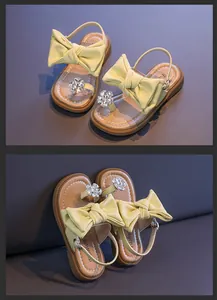 Close-up detail of stylish girls' sandals featuring large yellow bows and rhinestone flowers