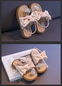 Detailed view of girls' pink bow sandals with sparkling rhinestone flower accents