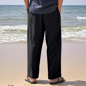 Back view of men's breathable black linen wide-leg casual pants in a sunny beach setting