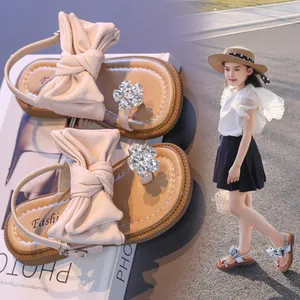 Elegant girls' summer sandals with a large ribbon bow and a sparkling rhinestone flower design.