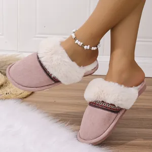 Close-up detail showing cozy pink plush slippers with thick faux fur trim worn indoors
