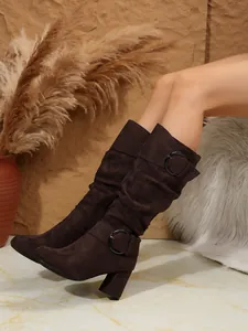Elegant dark brown suede mid-calf boots featuring decorative buckles and high heels.