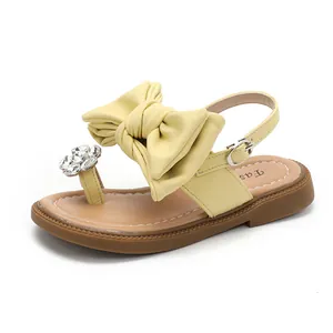 Elegant yellow girls sandals featuring a large bow and rhinestone flower accent.