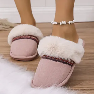 Close-up of pink plush slippers with white fur trim and patterned band details