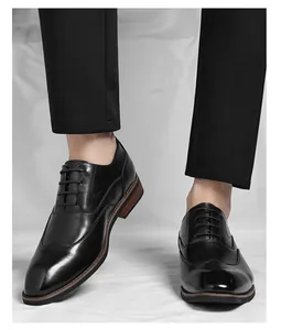 Close-up detail of men's black leather Oxford dress shoes worn with dark suit trousers