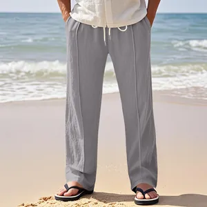 Detailed view of gray linen straight-leg casual trousers for men in a beach setting.