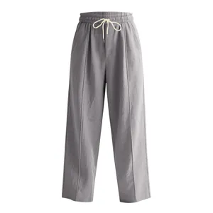 Detailed view of grey linen wide-leg trousers with elastic drawstring waist.