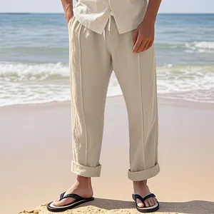 Detail view of men's breathable beige linen wide-leg casual trousers on the beach