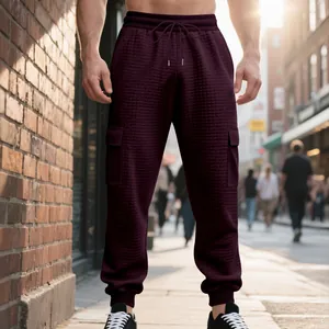 Detailed view of men's burgundy cargo joggers with unique jacquard texture and pockets
