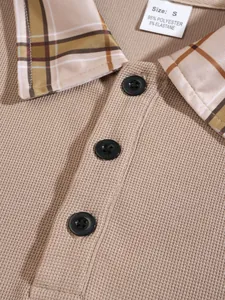 Close-up of men's polo shirt showing waffle-knit fabric, plaid collar, and buttons.