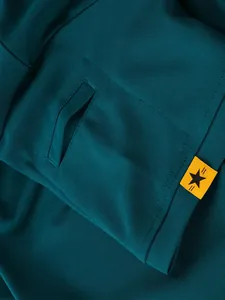 Detailansicht des dunkelgrünen Quick-Dry-Poloshirts mit Tasche und gelbem Stern-Label.