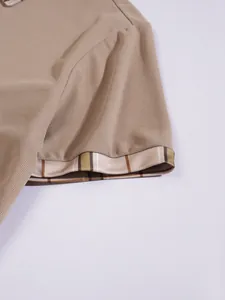 Detail view of the breathable waffle texture and plaid cuff on a tan men's polo shirt
