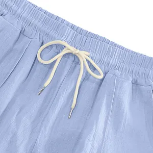 Close-up detail of elastic waistband and cream drawstring on men's blue linen pants