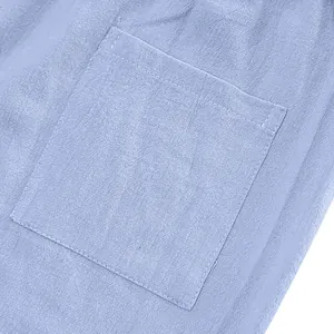 Close-up of the square pocket and breathable linen fabric texture on blue casual pants