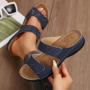 Détail de sandales compensées bleu marine avec strass brillants et coutures