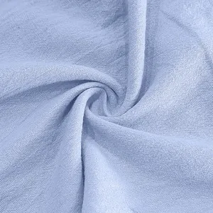 Macro shot showing the texture of light blue breathable linen fabric for men's beach pants.