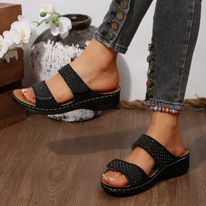 Élégantes sandales compensées noires avec brides en strass et fermeture velcro au pied.