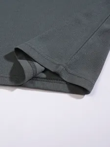 Close-up of grey waffle knit fabric and hem on a men's breathable sports polo shirt
