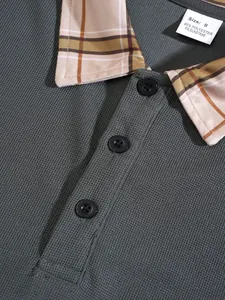 Macro detail of textured grey polo shirt featuring plaid collar and black buttons
