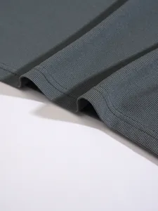 Close-up macro view showing the breathable waffle knit texture of a charcoal polo shirt