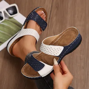 Gros plan sur des sandales compensées bicolores bleu et blanc avec détails en strass