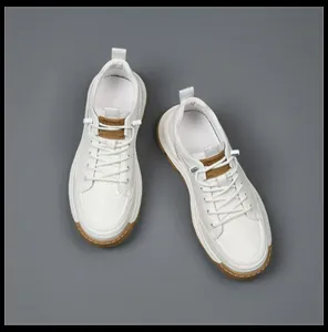 Vista dall'alto di sneakers bianche da uomo con dettagli in pelle marrone e suole in schiuma