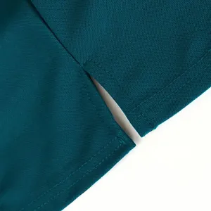 Seitenschlitz-Detail eines petrolfarbenen Polo-Shirts mit Naht