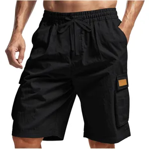 Detail view of men's black tactical cargo shorts with multi-pocket design on model