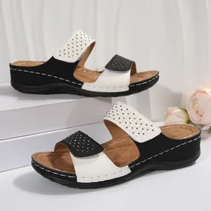Détail de sandales compensées pour femmes avec design color-block, velcro et strass.