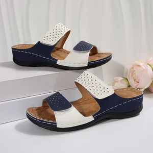 Gros plan de sandales compensées pour femmes avec détails en strass et brides Velcro