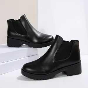 Detalle de los botines Chelsea negros para mujer con una suela dentada muy gruesa.