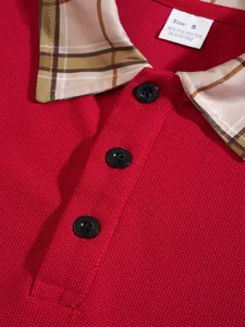 Detail of red men's polo shirt featuring plaid collar and breathable pique fabric.