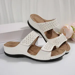 Vue détaillée de sandales compensées blanches avec décorations strass et brides velcro
