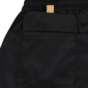 Close-up detail of black cargo shorts featuring a functional flap pocket and durable fabric.