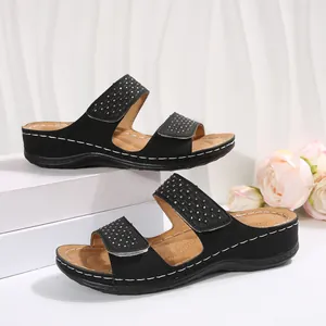 Vue détaillée de sandales compensées noires pour femmes avec lanières en strass.