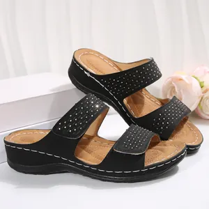 Vue détaillée de sandales compensées noires avec brides ornées de strass et fermeture Velcro.