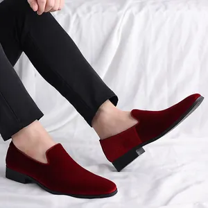 Vista detallada de mocasines de terciopelo burdeos para hombre con pantalones negros