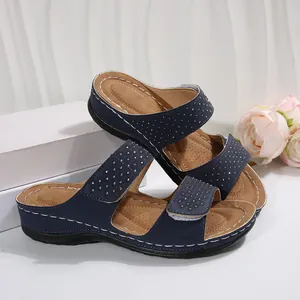 Détail de vue latérale de sandales compensées bleu marine avec strass et brides velcro