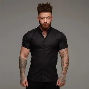 Front view of a men's muscle fit black short sleeve shirt in a studio setting.