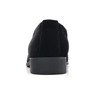 Vista posterior de mocasines clásicos de ante negro para hombre con tacón sobre blanco