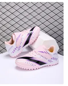 Detailed view of pink kids' TF turf soccer shoes featuring easy hook and loop strap closure