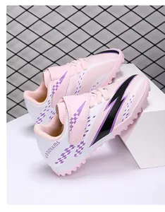 Close-up of pink kids' TF football boots with lightning pattern and velcro strap