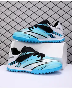 Blue children's turf soccer shoes with velcro straps, lightning pattern, and checkered design.
