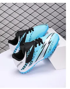 Detailed view of blue and black youth TF turf soccer shoes with Velcro straps.
