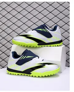 Side view of children's soccer shoes with velcro strap and neon green turf sole.